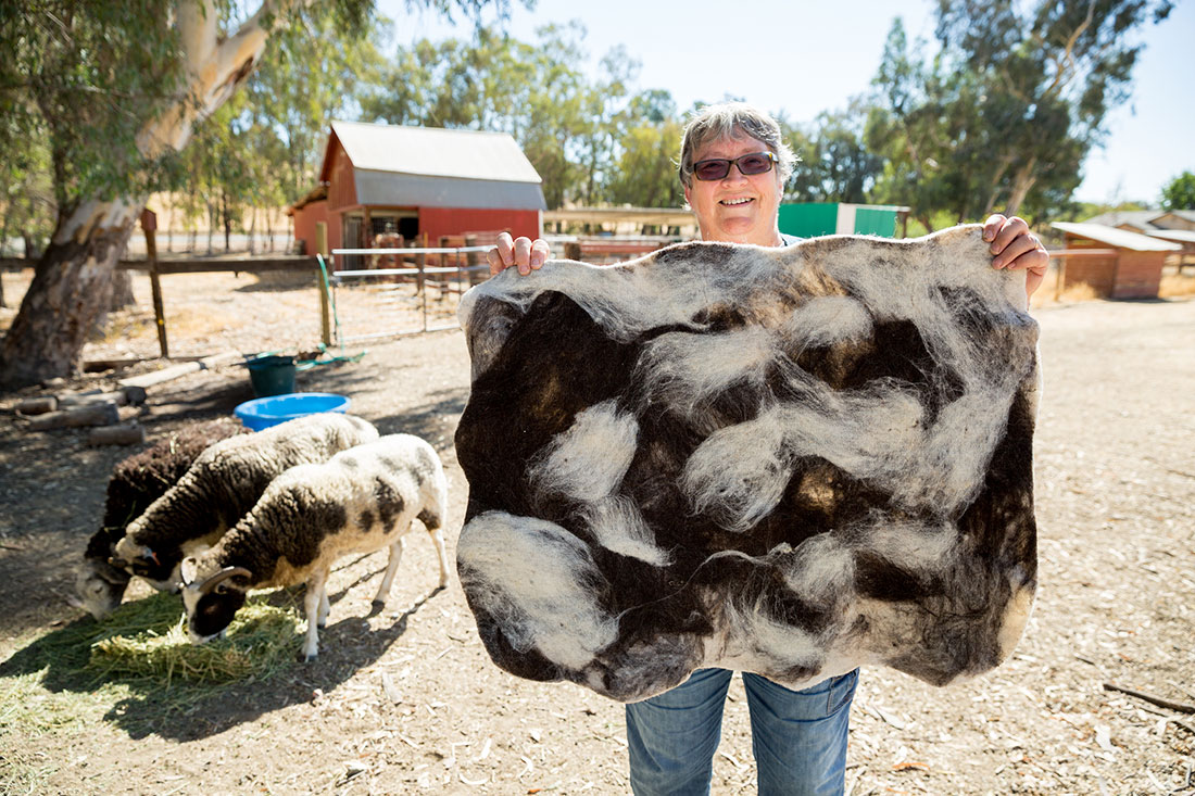 Jackie Post holds a felted rug that she made